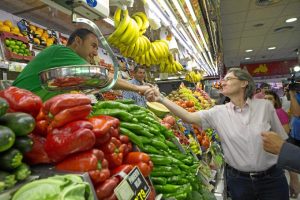 Marta Higueras saludando a uno de los vendedores del mercado Guillermo de Osma.